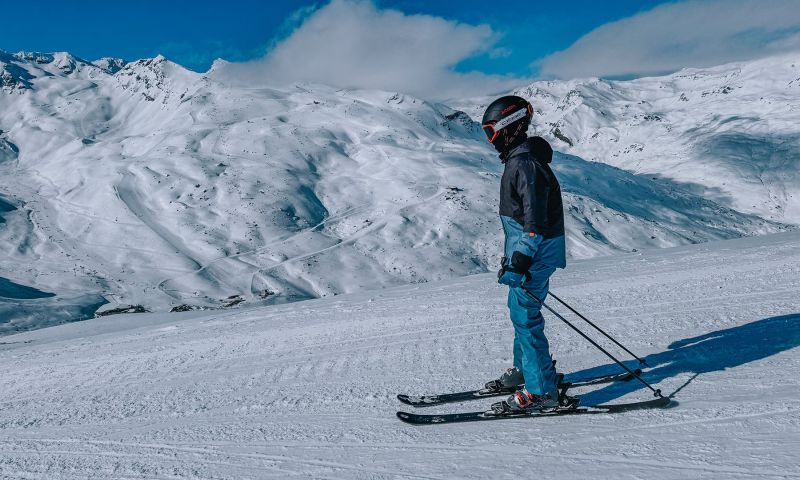 Familie beim Skifahren auf schneebedeckten Pisten in Warth-Schröcken am Arlberg mit klar blauem Himmel im Hintergrund, im größten Skigebiet Österreichs.